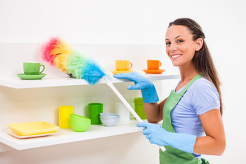 Young happy woman is cleaning the kitchen. 