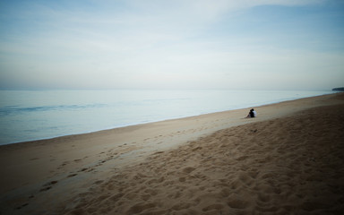 Obraz premium Romantic portrait of attractive couple in love hugs sitting on the beach