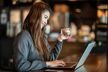 Beautiful Attractive Business Asian woman working with laptop and looking in monitor smile and have positive emotional feeling so happiness,Business Startup Concept,Warm Tone