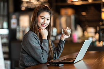 Beautiful Attractive Business Asian woman working with laptop and looking in monitor smile and have positive emotional feeling so happiness,Business Startup Concept,Warm Tone