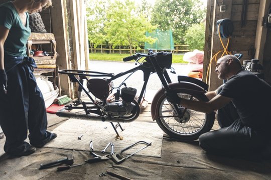 Mechanic repairing motorbike in garage