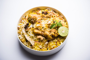 Delicious spicy chicken biryani in bowl over moody background, it’s a popular Indian and Pakistani food.