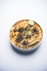 mutton or lamb biriyani with basmati rice, served in a bowl over moody background.