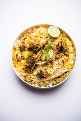 mutton or lamb biriyani with basmati rice, served in a bowl over moody background.
