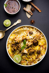mutton or lamb biriyani with basmati rice, served in a bowl over moody background.