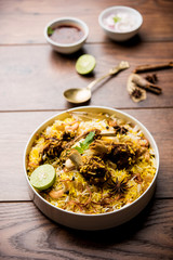 mutton or lamb biriyani with basmati rice, served in a bowl over moody background.