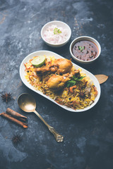 Delicious spicy chicken biryani in bowl over moody background, it’s a popular Indian and Pakistani food.