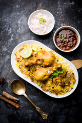 Delicious spicy chicken biryani in bowl over moody background, it’s a popular Indian and Pakistani food.