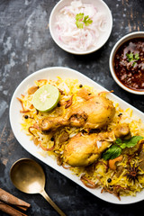 Delicious spicy chicken biryani in bowl over moody background, it’s a popular Indian and Pakistani food.