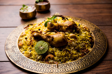 Delicious spicy chicken biryani in bowl over moody background, it’s a popular Indian and Pakistani food.