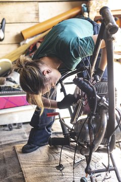 Female mechanic repairing motorbike in garage