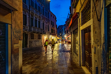 Fototapeta na wymiar Tourist couple on the night streets of Venice