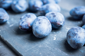 Fresh ripe plums on the rustic background. Selective focus. Shallow depth of field.