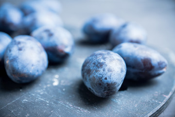 Fresh ripe plums on the rustic background. Selective focus. Shallow depth of field.