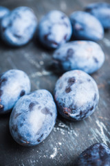 Fresh ripe plums on the rustic background. Selective focus. Shallow depth of field.