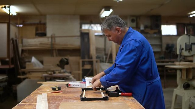Assembling the wooden frame on the carpentry table in the workshop