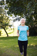 Senior woman jogging through park
