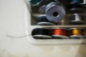 Closeup set of colored thread for a sewing machine. Workplace seamstress. Tailoring industry