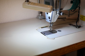 Close-up of a sewing machine with light on. workplace tailor. sewing industry