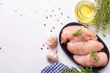 Raw uncooked chicken breasts  in bowl  with ingredients for cooking