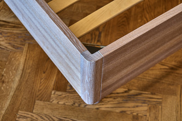 Solid wood bed. Modern scandinavian style. Close-up. Empty bedroom