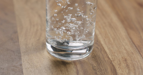 Closeup pour clean water into glass on wood table