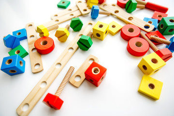 Closeup of toy wooden bricks and sticks on white table background