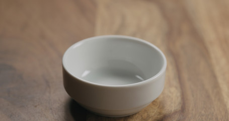 Obraz na płótnie Canvas Small empty white bowl on wood background