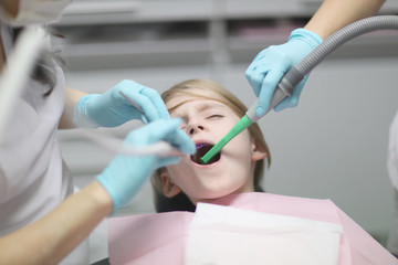 school age boy lying in the dental chair at a reception at the doctor dentist