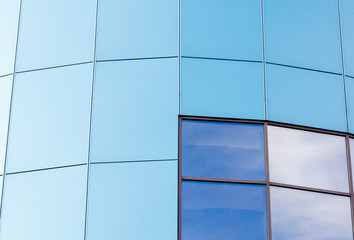 wall of the building with blue panels and a mirrored window