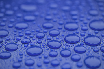 Closeup waterdrops on blue ceramic coated paint surface