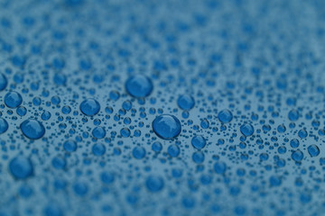 Closeup waterdrops on blue ceramic coated paint surface