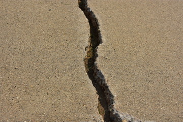 Cracks in concrete city sidewalk.