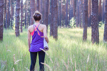 woman walking with a yoga mat