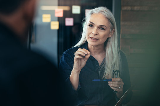 Mature business woman advising her colleagues in meeting