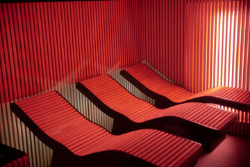Red light colored empty sauna chairs