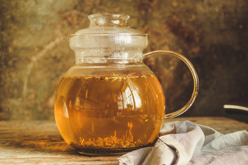 tea in a transparent teapot on the table (herbal tea is brewed). top view.