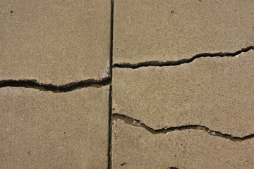 Cracks in concrete city sidewalk.