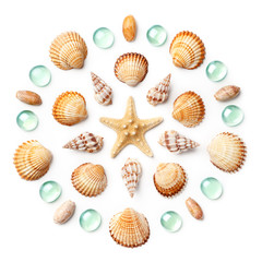 Pattern in the form of a circle made of shells, starfish and green glass beads isolated on white background