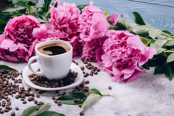 Beautiful flowers peonies next to a cup of coffee