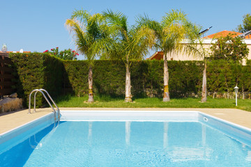 Small swimming pool with clean, blue water in the yard of a private house