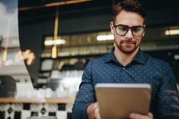 Businessman using tablet computer sitting at a cafe