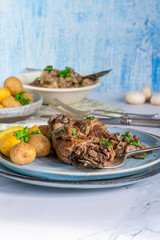Beef roulade staffed with mushrooms in creamy mushroom sauce served with boiled baby potatoes