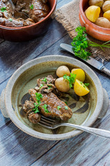 Beef tenderloin staffed with mushrooms in creamy mushroom sauce served with boiled baby potatoes - high angle view