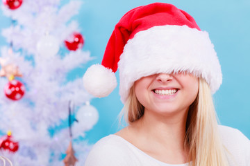 Woman wearing Santa hat that covers her eyes