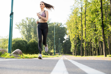 Young pretty woman with perfect slim body running outdoors. Fitness and running concept.