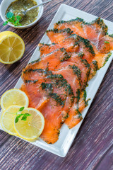 Gravadlax - Nordic dish of thinly sliced raw salmon cured in salt, sugar and dill and accompanied by dill and mustard sauce - top view