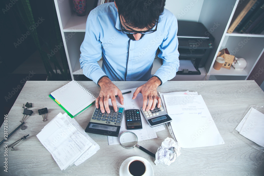 Poster business person calculating invoices using calculator in office