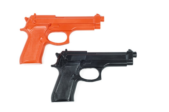 black and orange plastic toy pistols white background