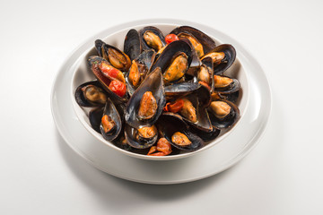 Bowl with cooked and open mussels